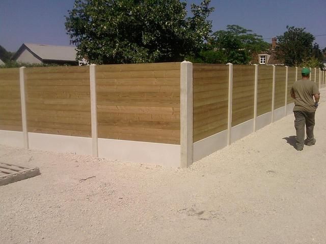 Clôture en bois et béton en angle.
