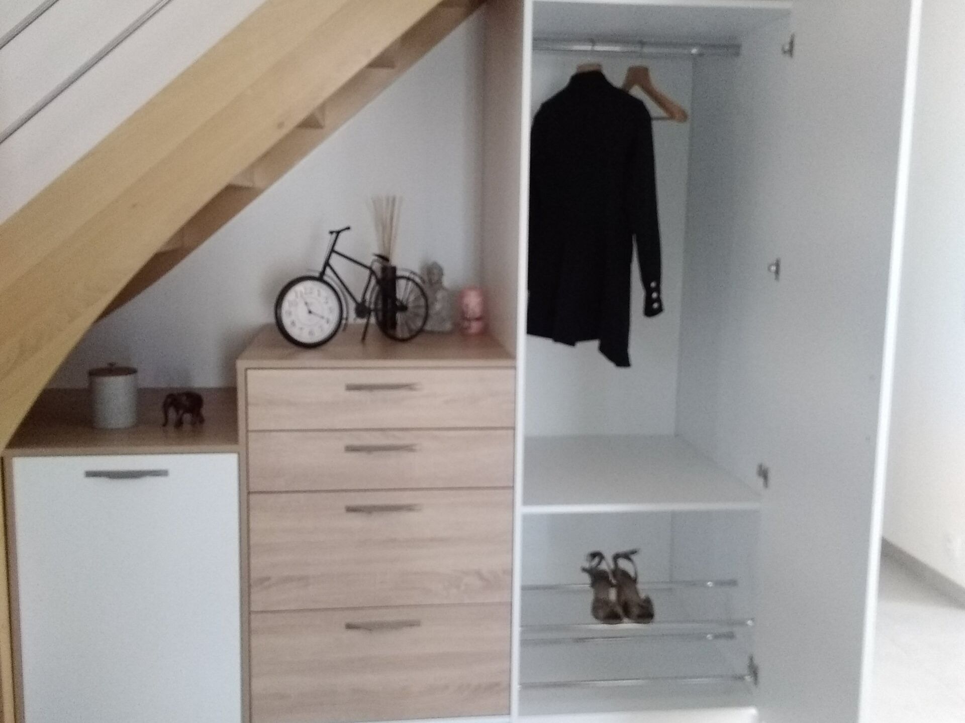 Rangements avec tiroirs et placards aménagés sous un escalier