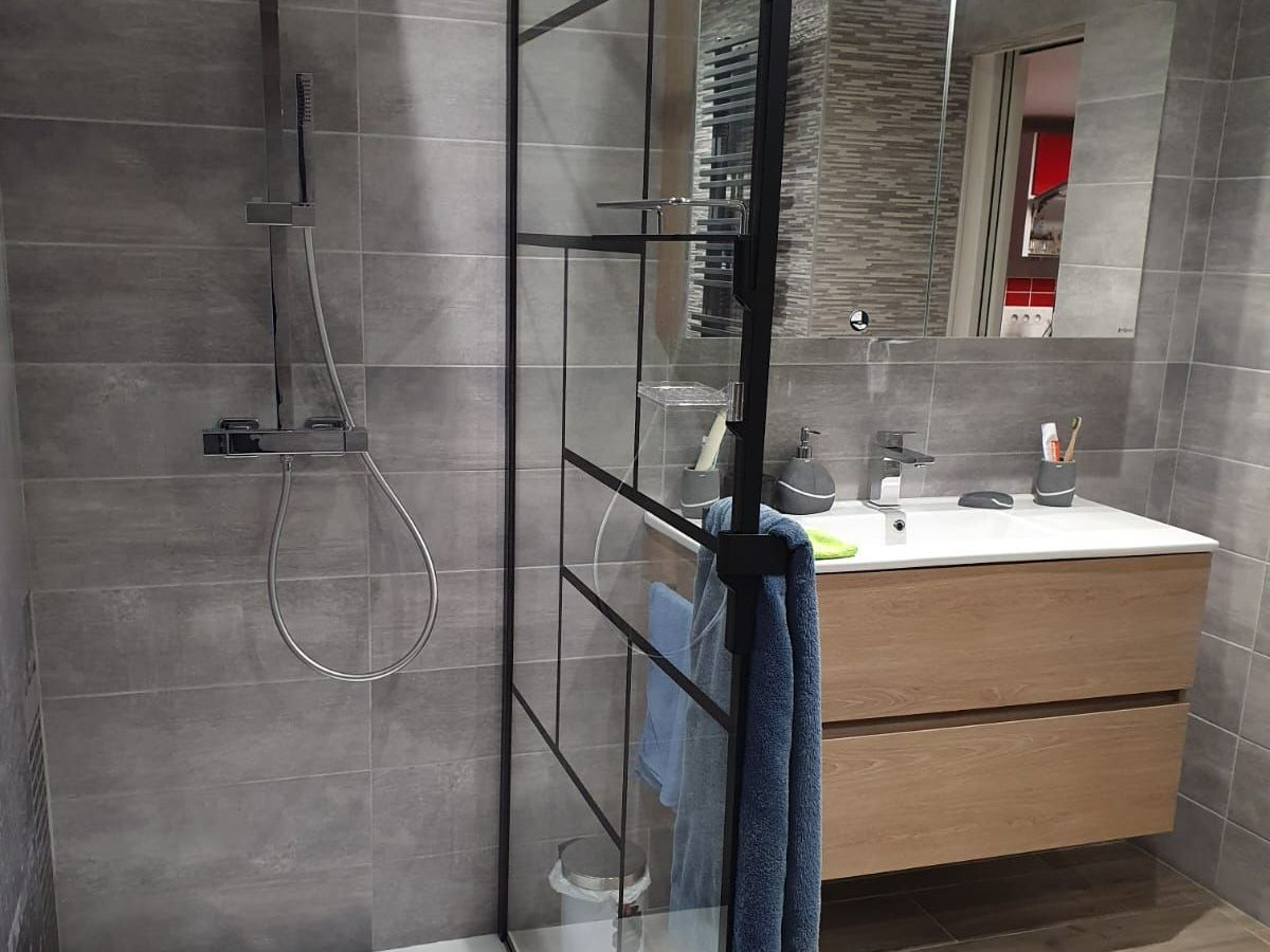Douche et lavabo séparés par une paroi vitrée