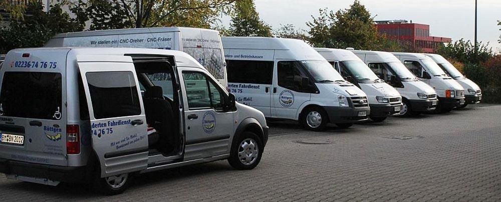 Eine Reihe weißer Lieferwagen steht auf einem Parkplatz