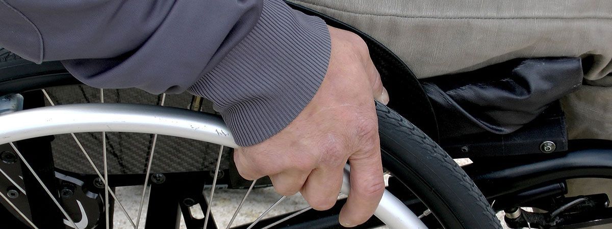 Eine Nahaufnahme der Hand einer Person auf einem Rollstuhl