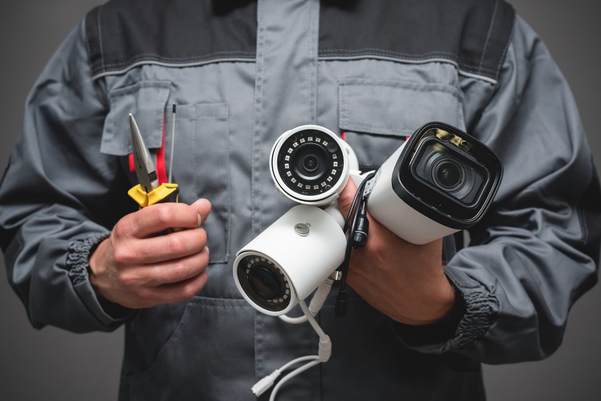 Un technicien tenant des outils et des caméras de surveillance