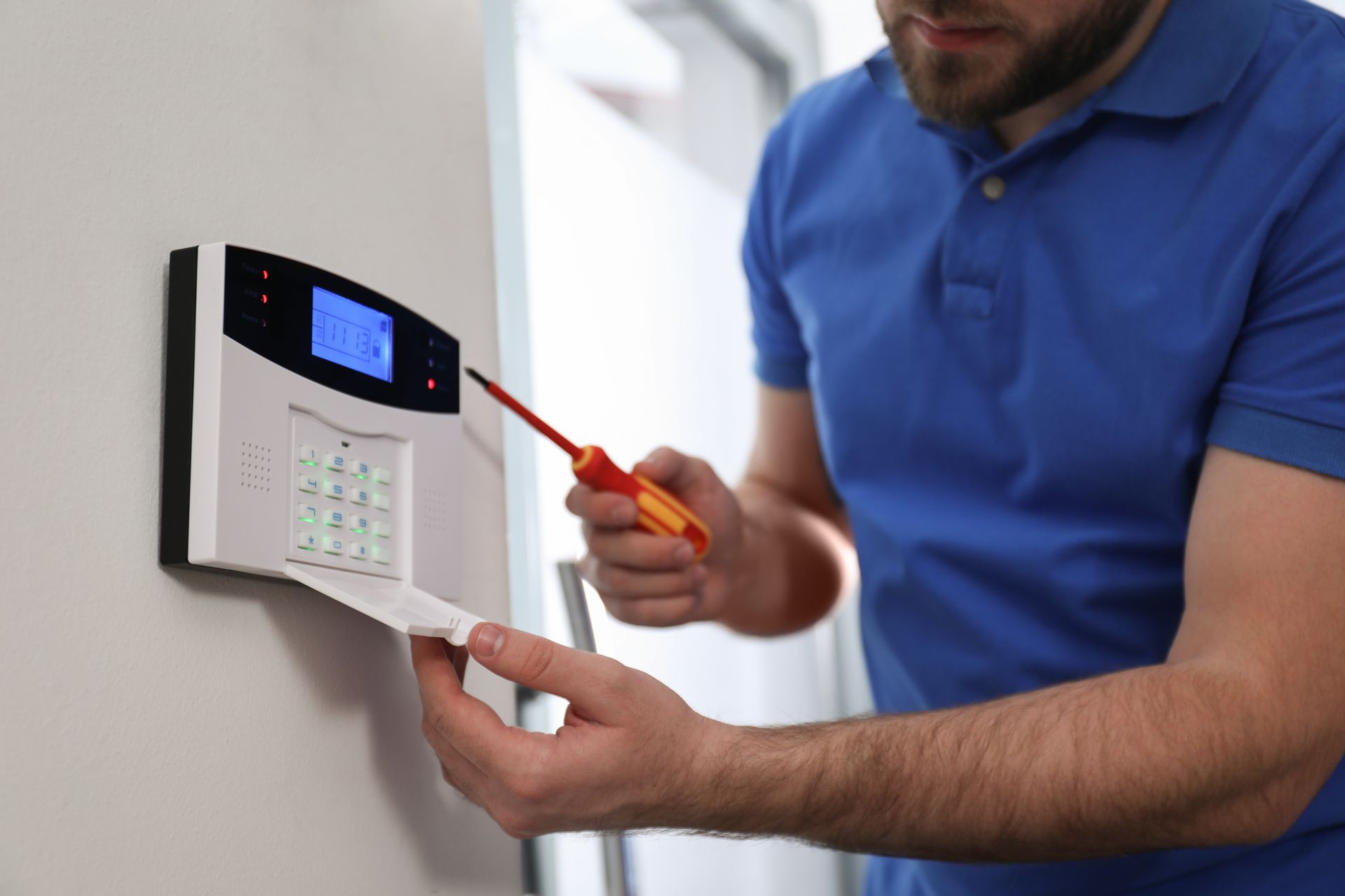 Un technicien qui installe la commande d'une alarme