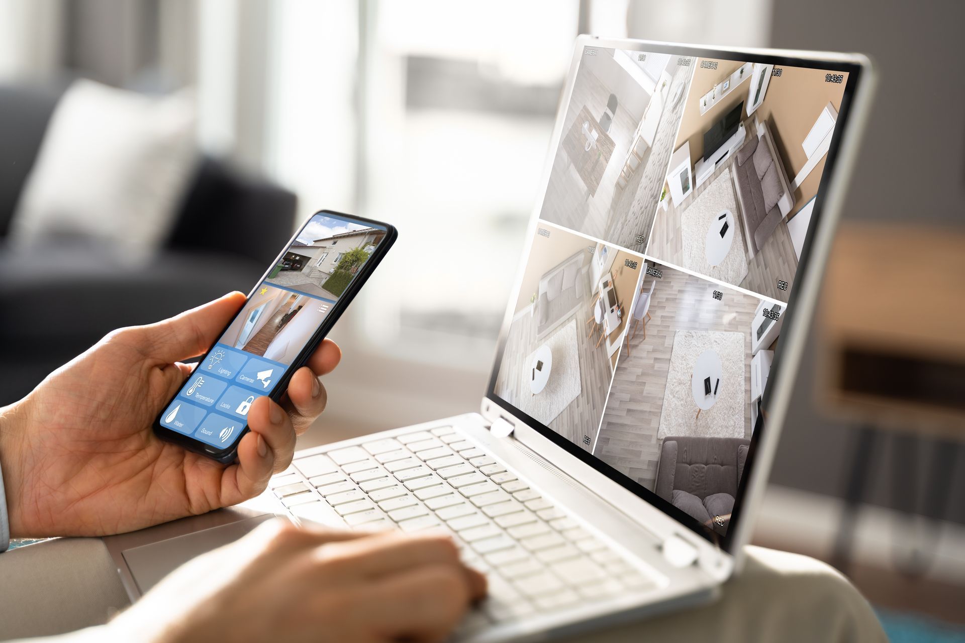 Gros plan sur un smartphone et un ordinateur avec des flux vidéo de caméra de surveillance