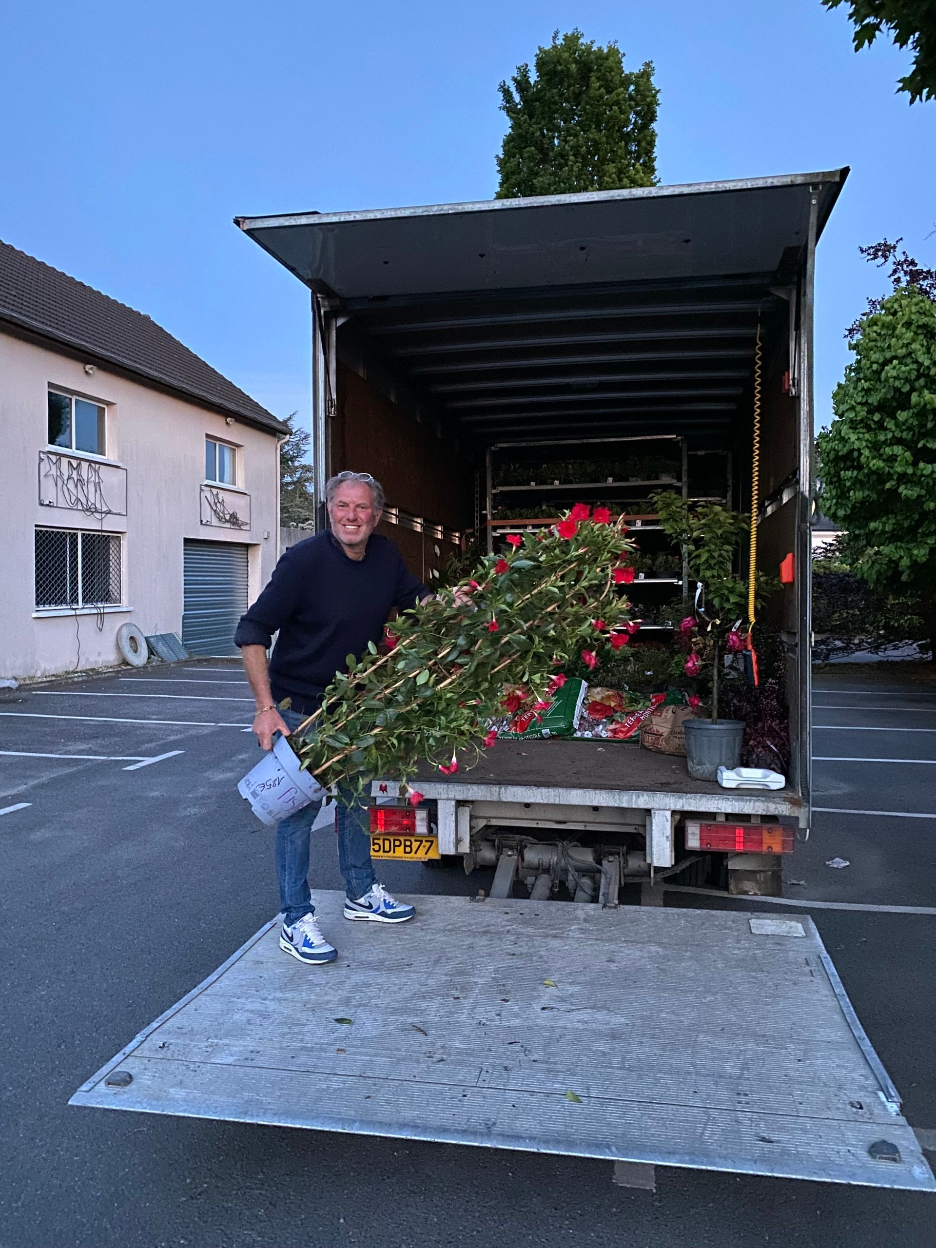 Un homme avec une plante fleurie