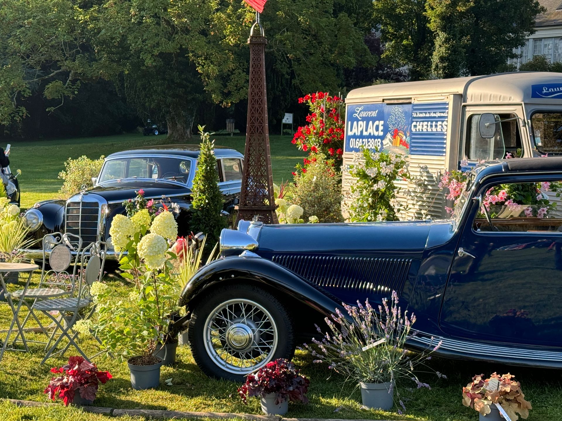Deux voitures anciennes au milieu d'un parc paysager