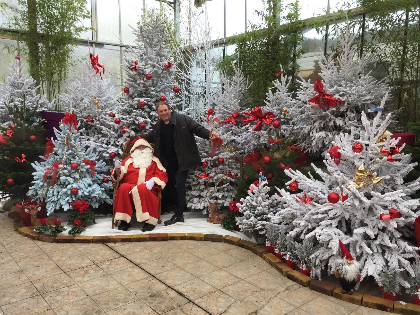 Un homme et le Père Noël au milieu de sapin
