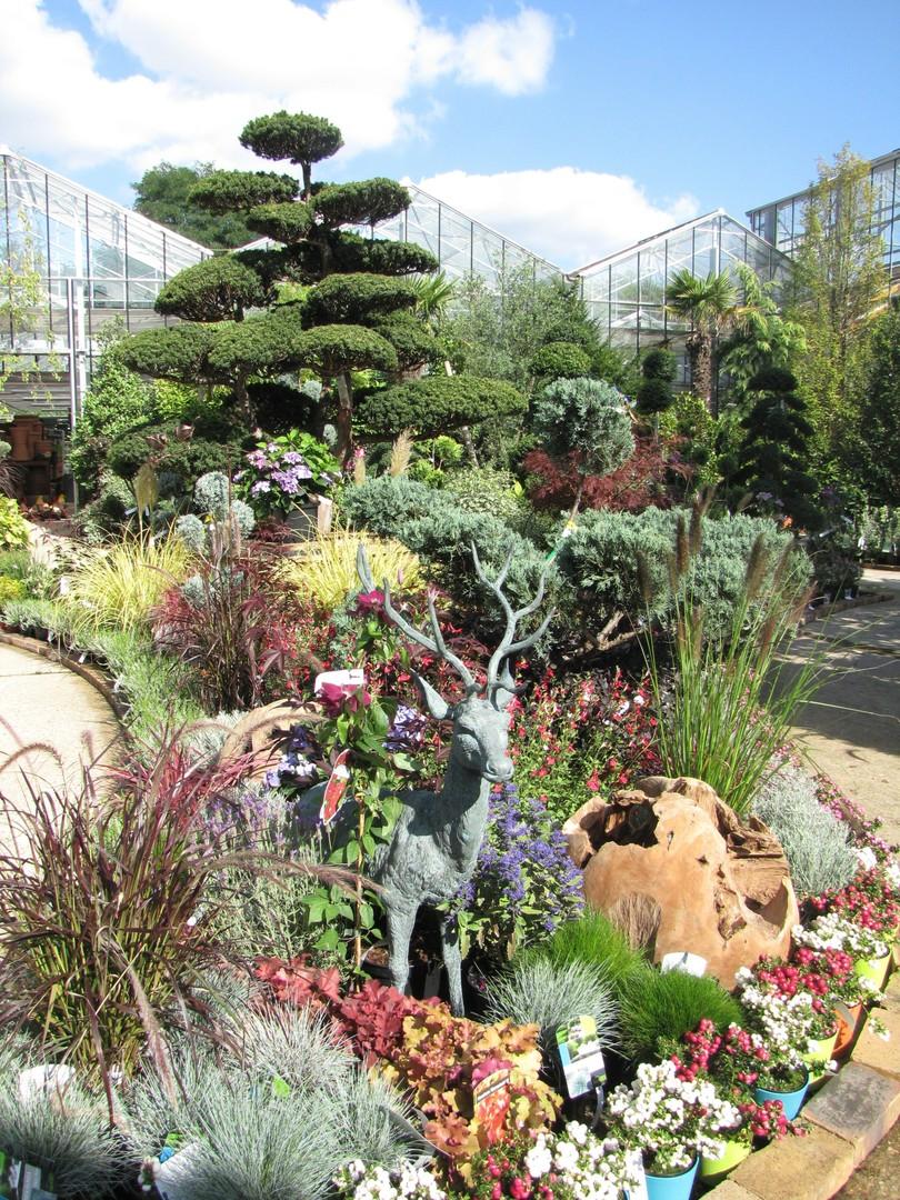 Statue d'un cerf entourée de végétation