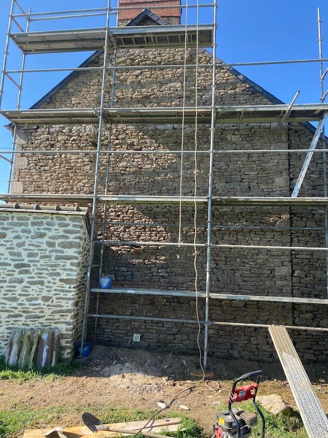 Bâtiment en pierre en rénovation, avec des échafaudages.