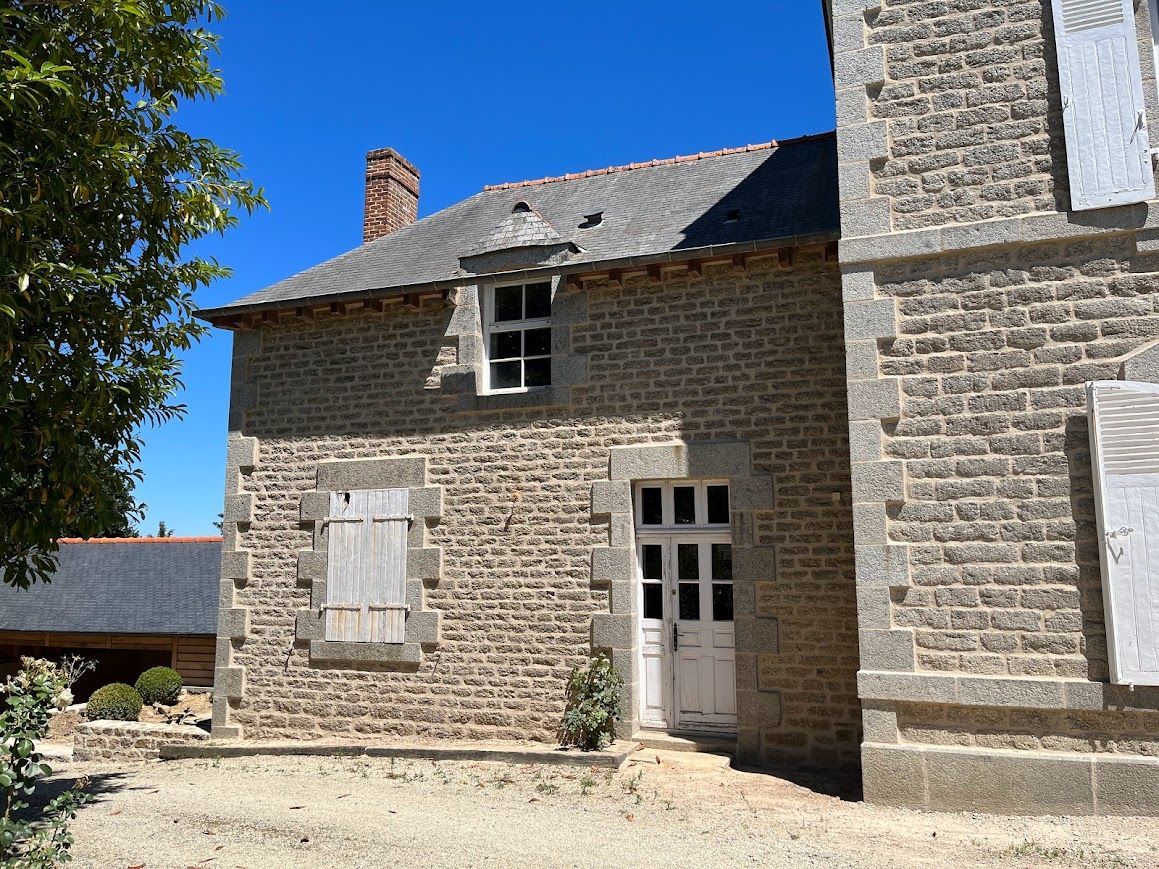 Ferme en pierre aux fenêtres à volets et à la porte.
