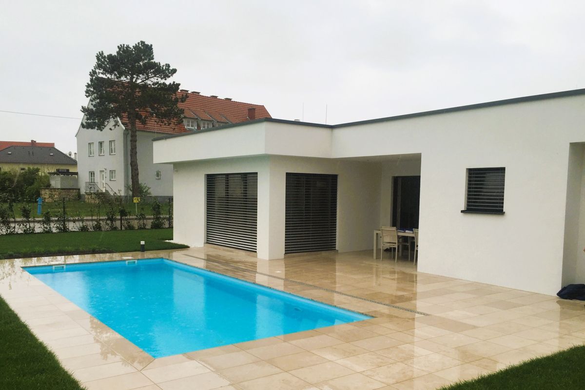 Ein weißes Haus mit einem großen Swimmingpool davor