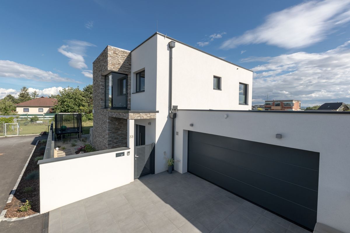 Ein weißes Haus mit einem schwarzen Garagentor