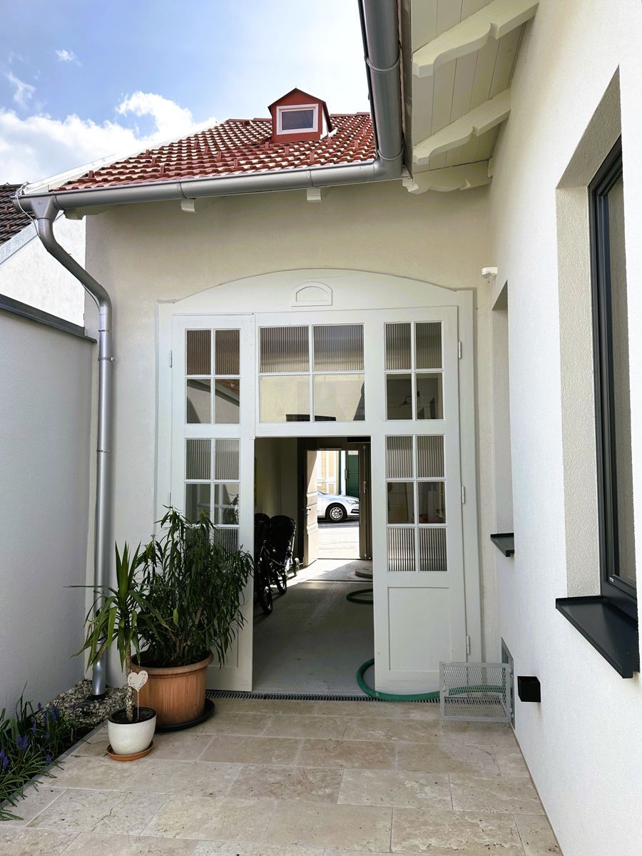 Ein weißes Haus mit einem roten Dach und einer weißen Tür