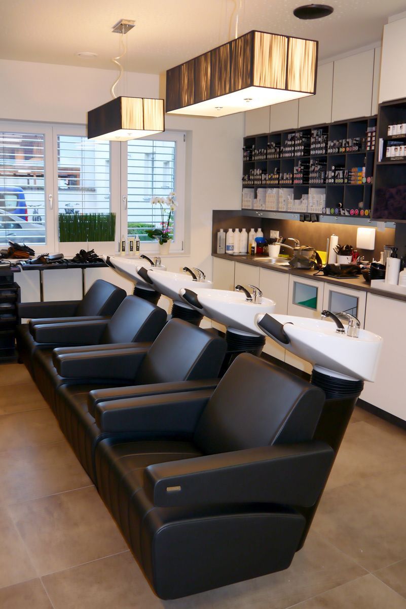 Ein Salon mit vielen Stühlen und Waschbecken