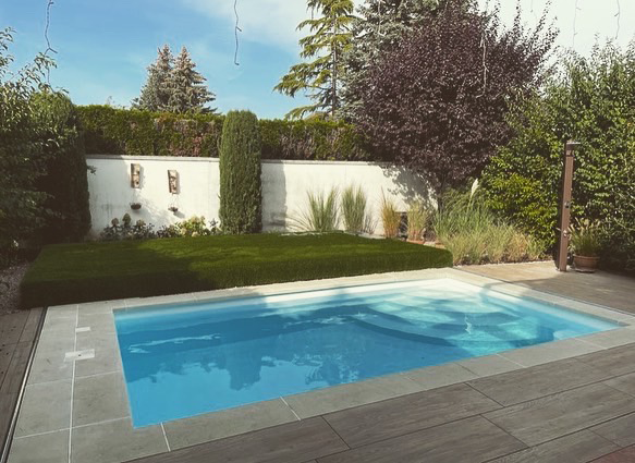 Ein weißes Haus mit einem braunen Dach und einem Holzzaun