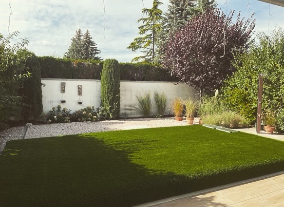 Ein weißes Haus mit einem braunen Dach und einem Holzzaun