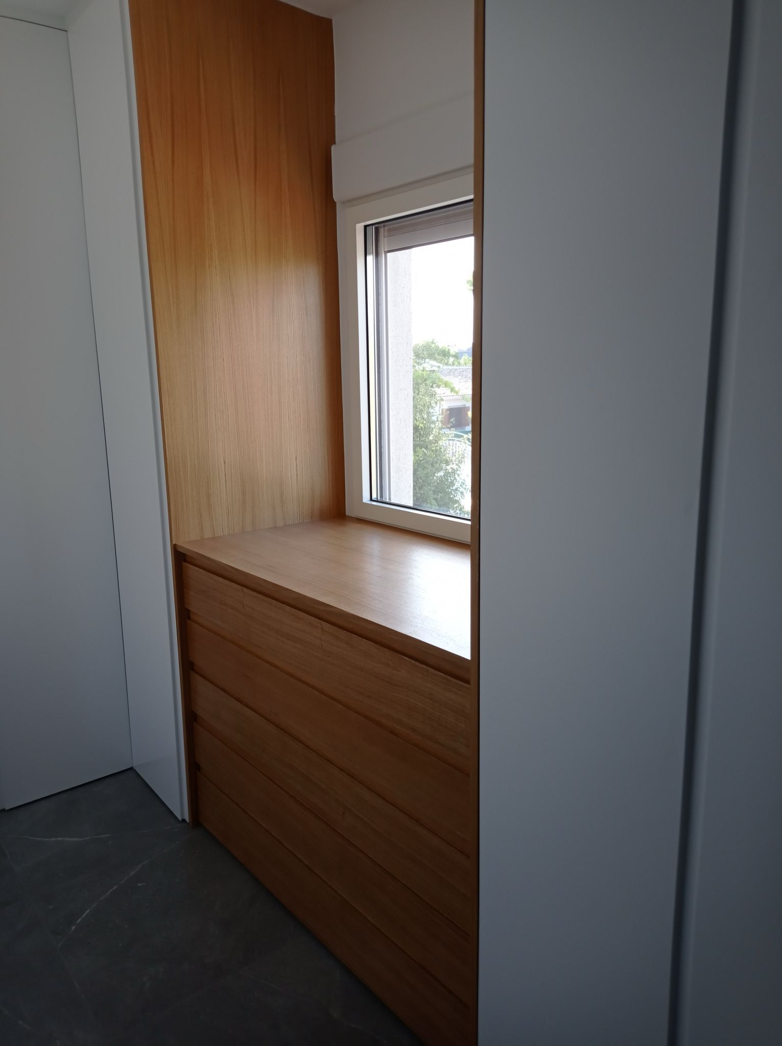 Un rincón de una habitación con una ventana y una cómoda.