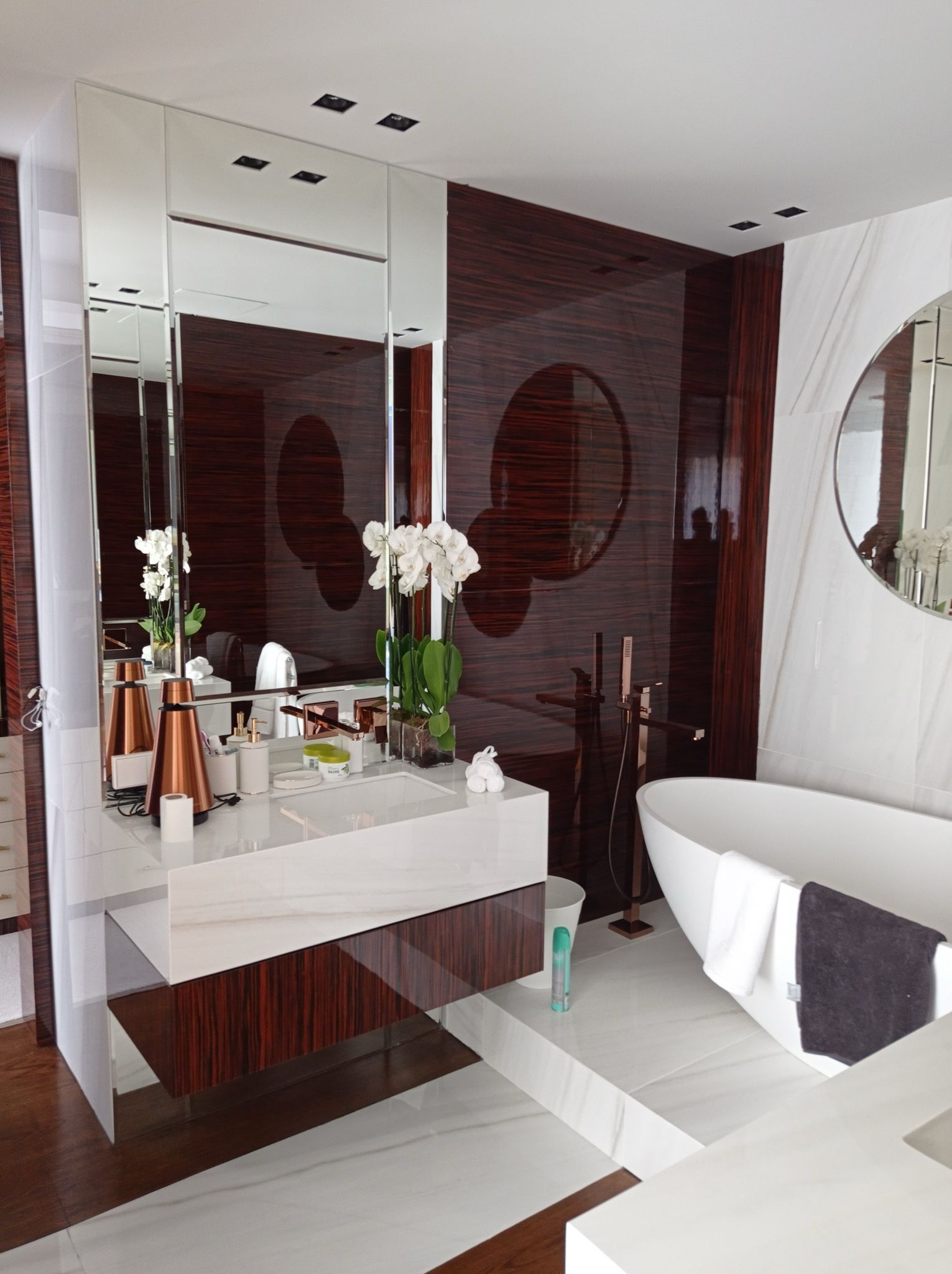 Un baño con bañera, lavabo y espejos.