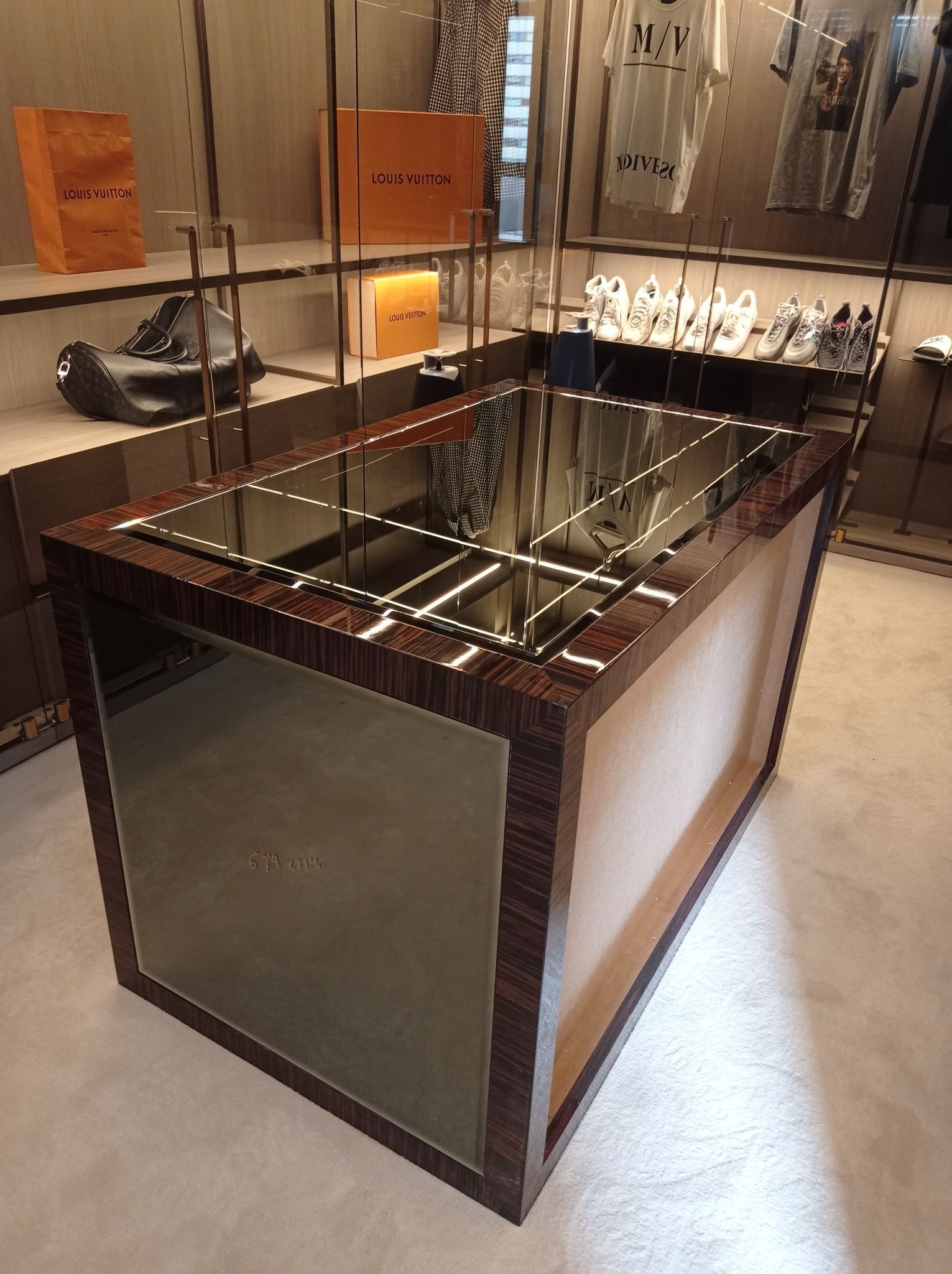 Una mesa con espejo y marco de madera en una tienda.