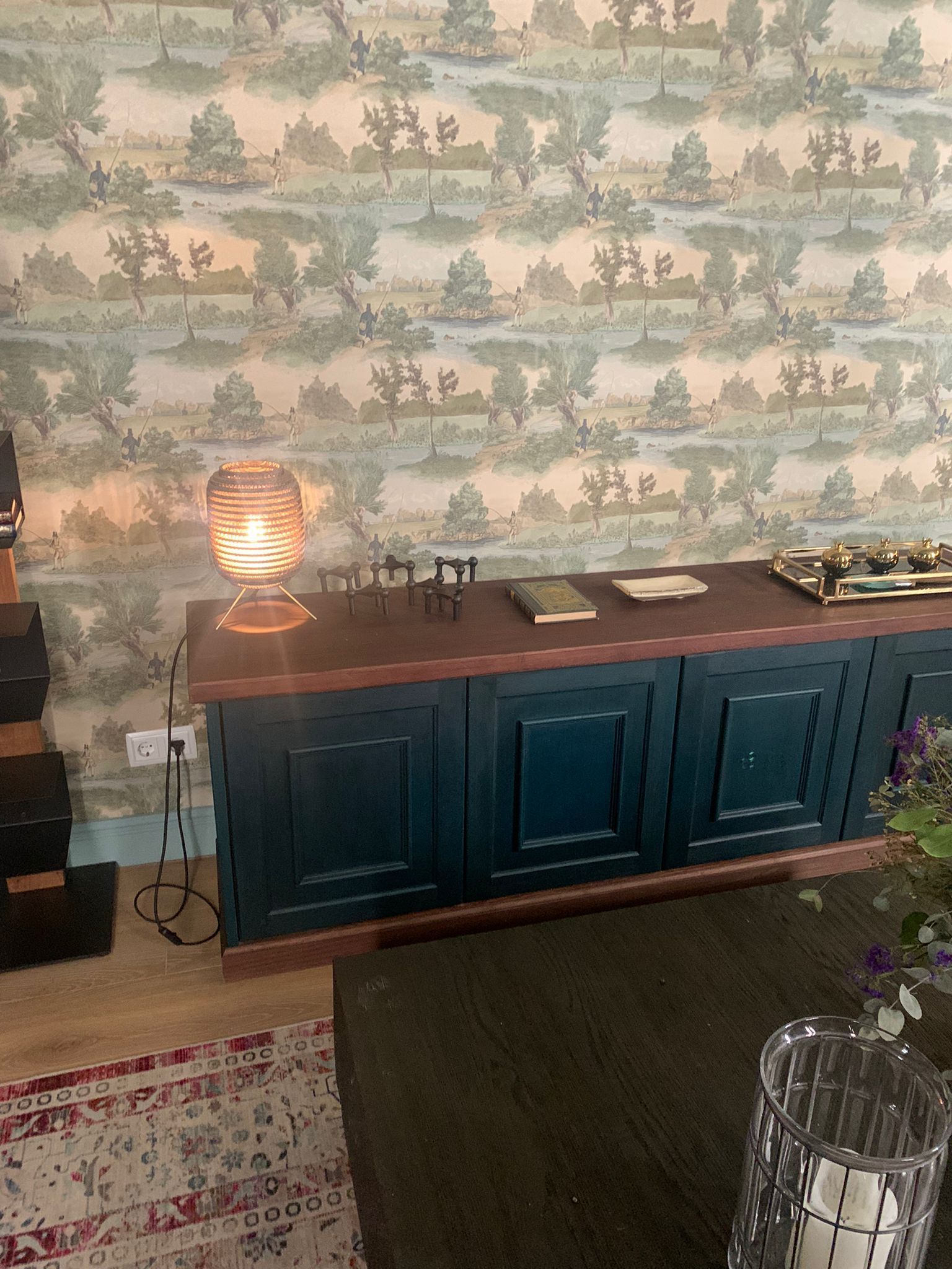 Una sala de estar con un armario azul y una lámpara encima.