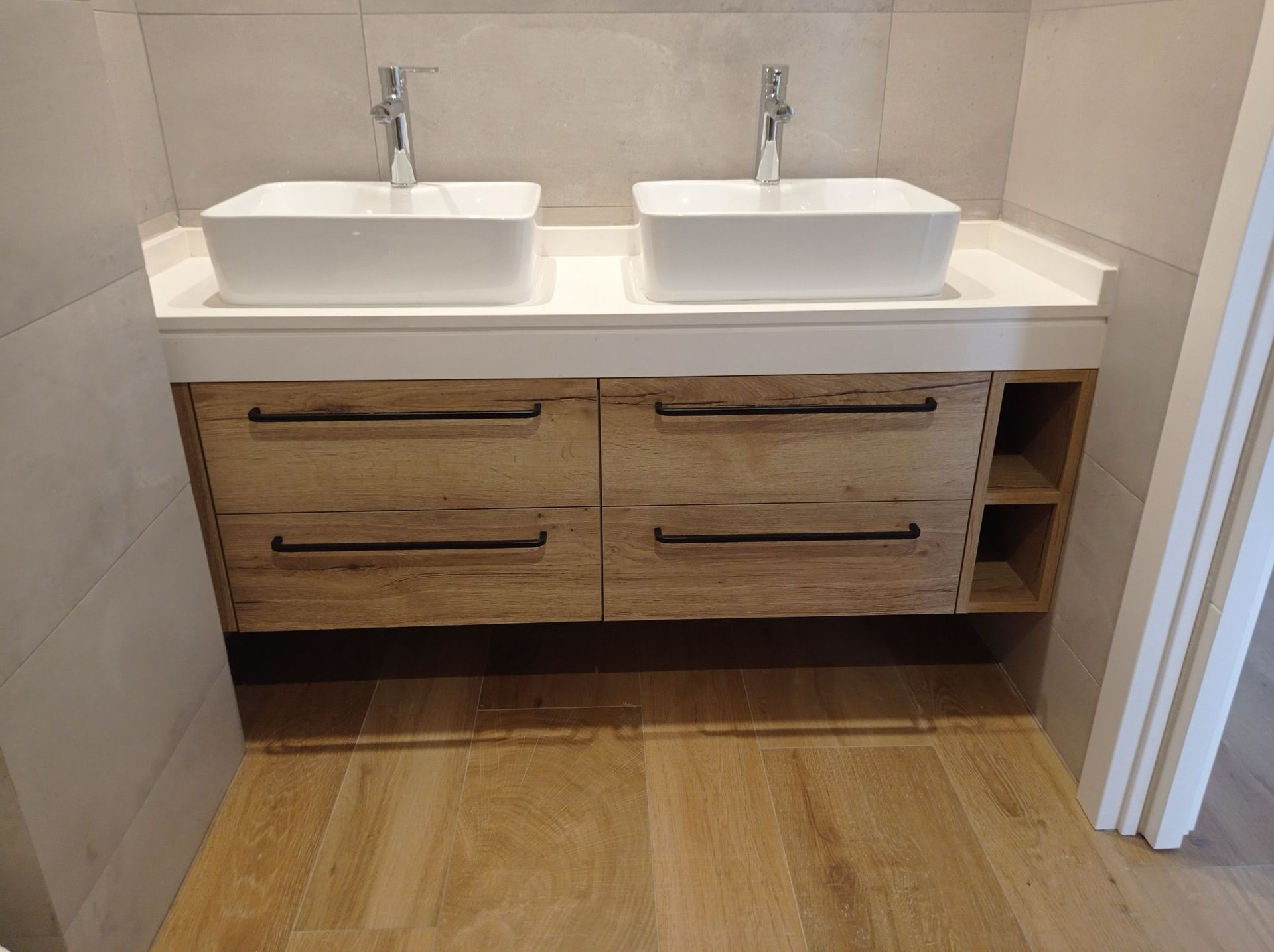 Un baño con dos lavabos y un tocador de madera.