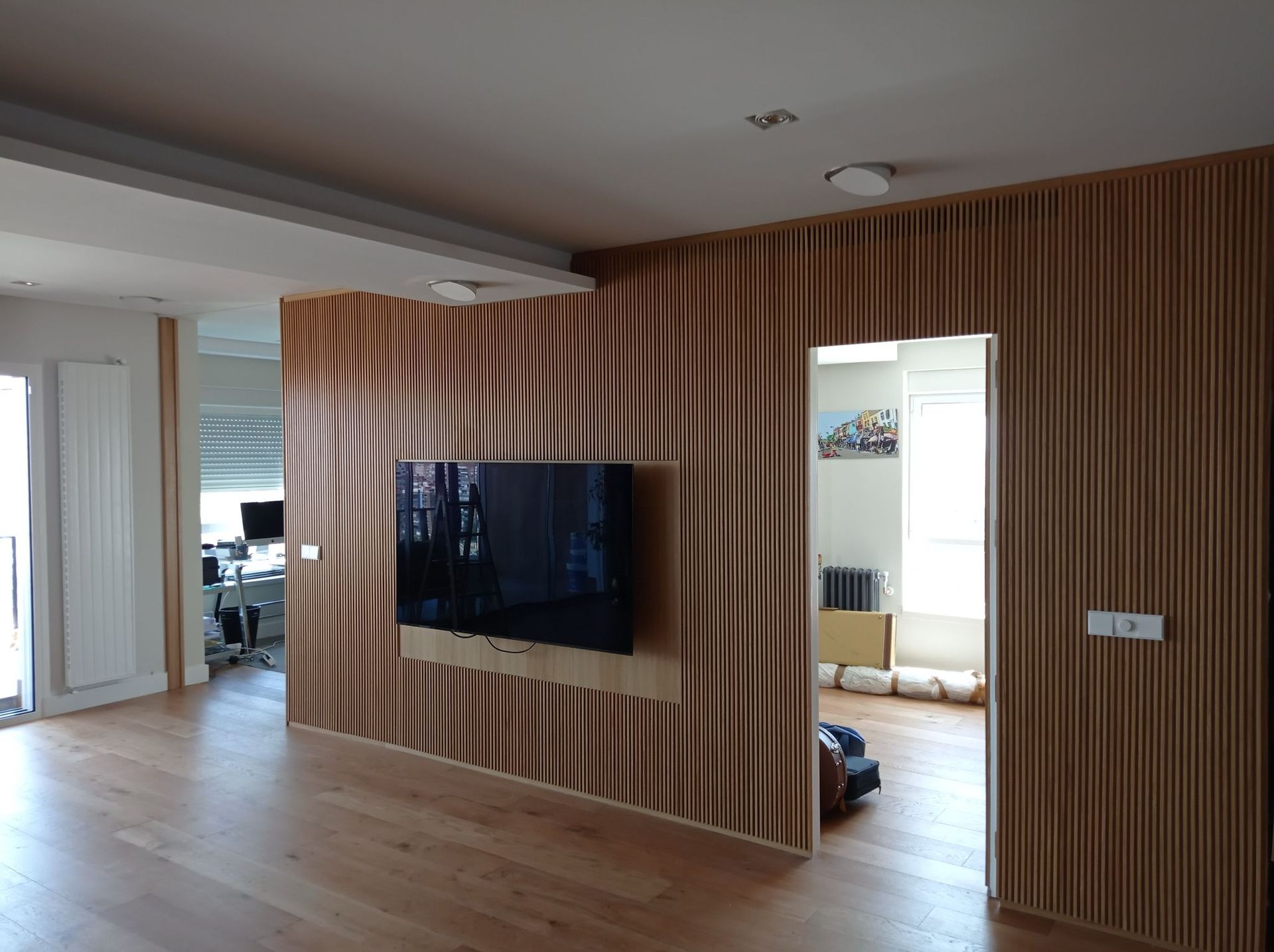 Una sala de estar con una pared de madera y un televisor de pantalla plana en la pared.