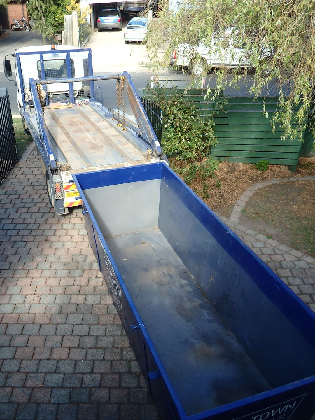 Livraison d'une benne dans la cour d'une maison