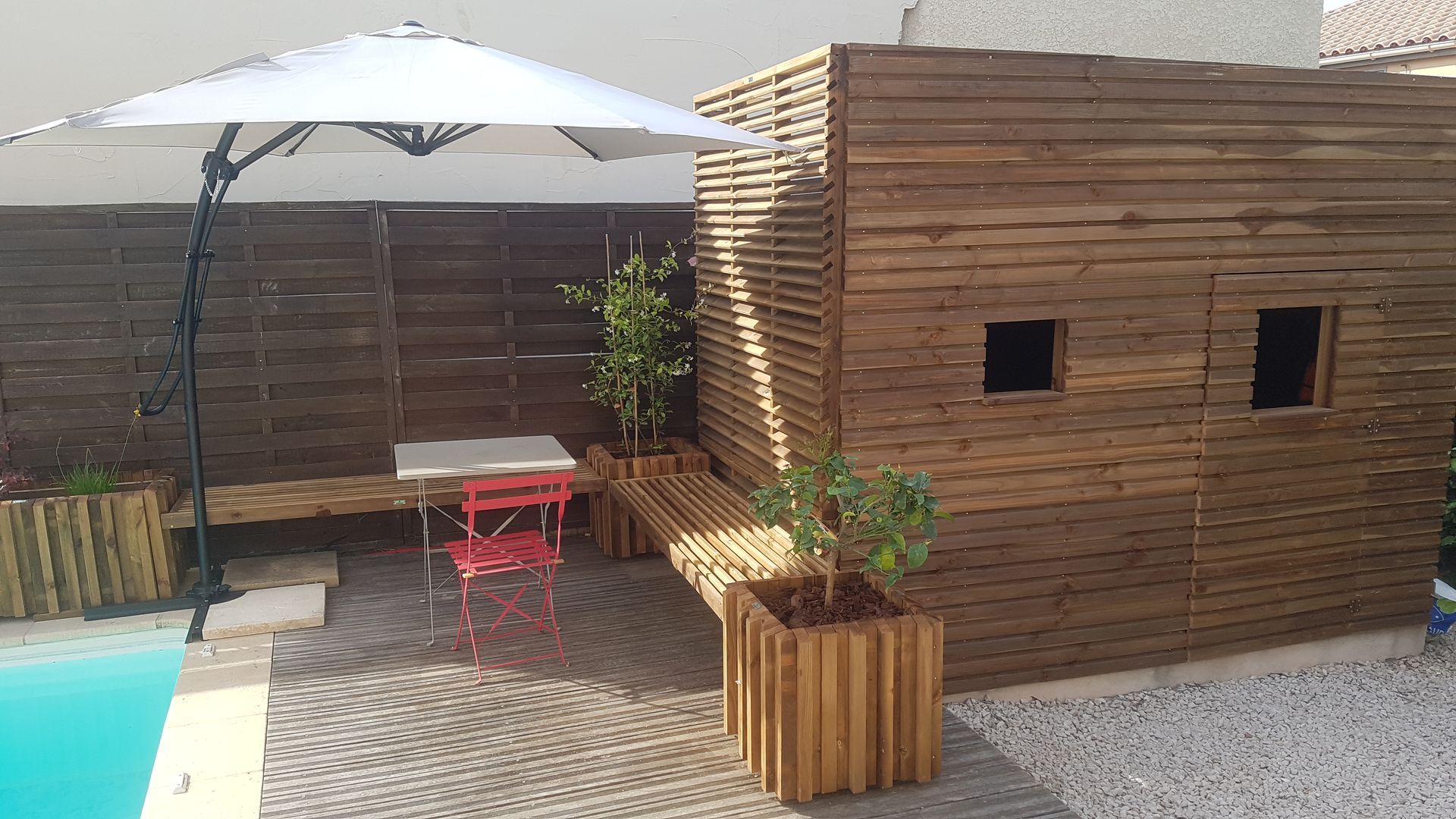 Une terrasse en bois avec une cabane.