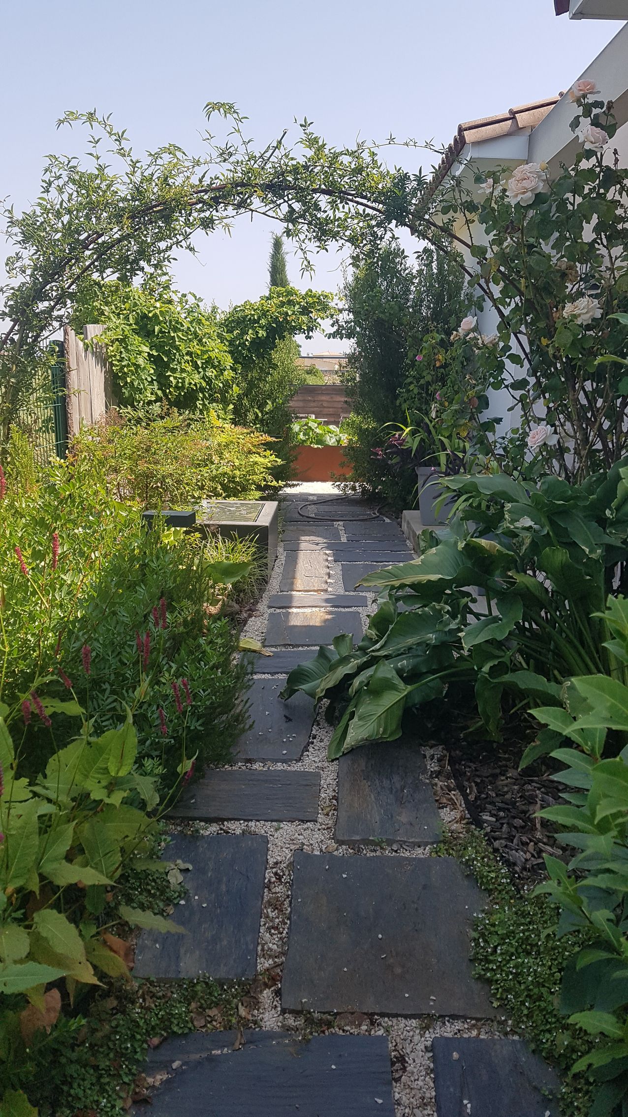 Une allée de jardin avec des dalles en ardoise.