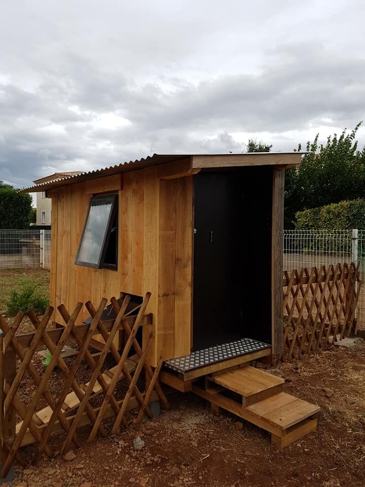 Une cabane à côté d'un potager.