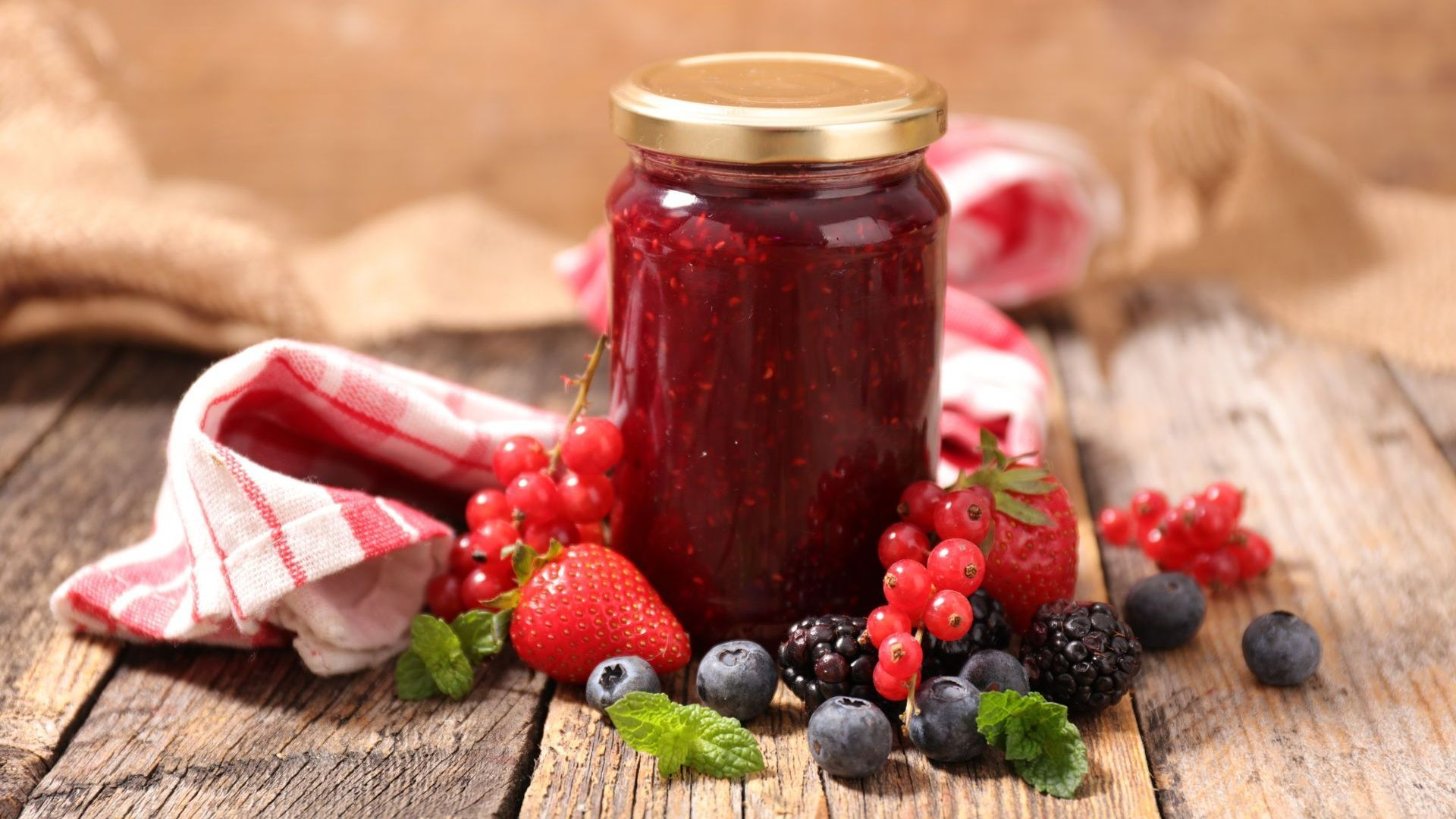 Fruits rouges et pot de confiture sur une table en bois