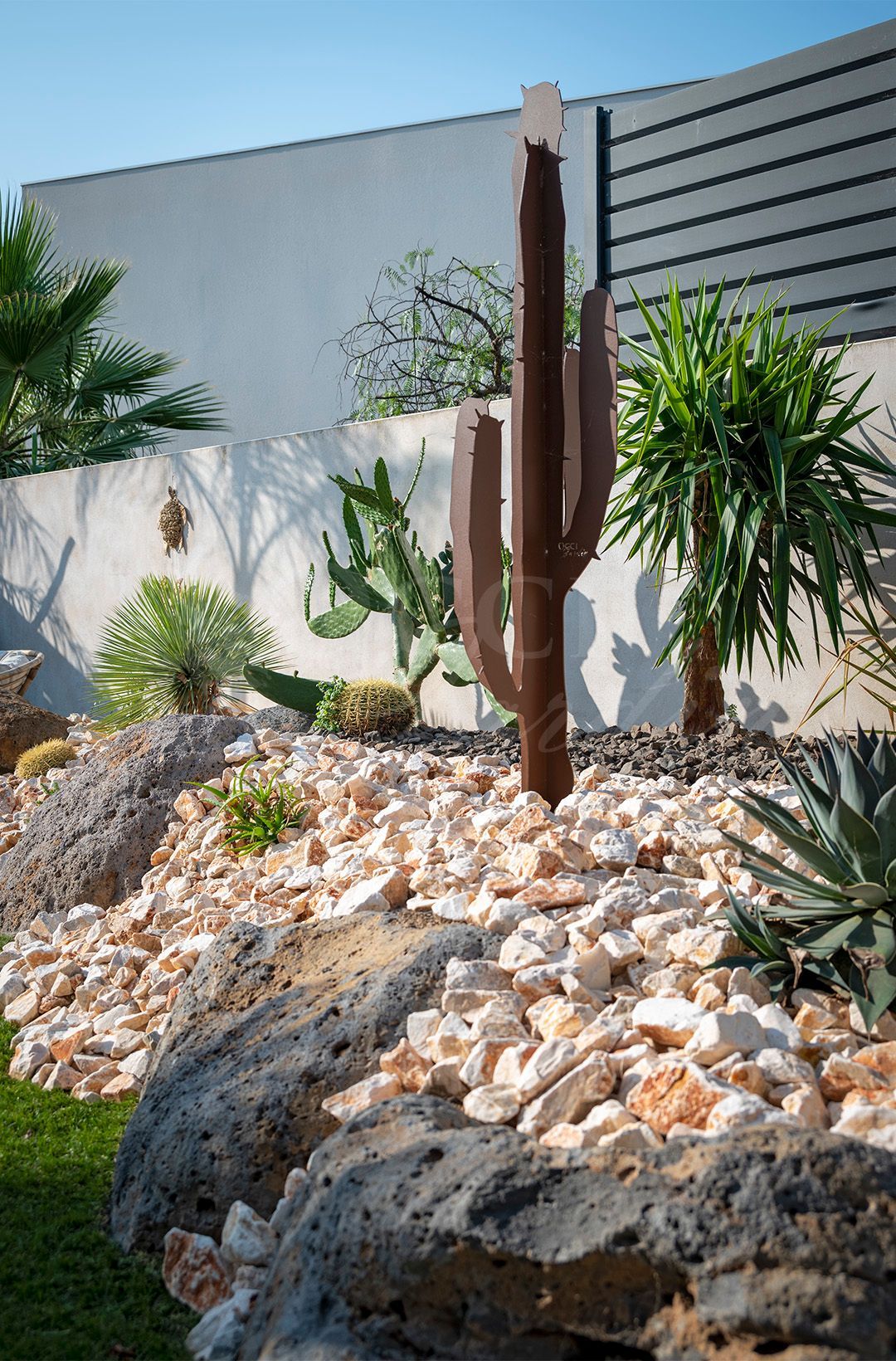 Un jardin avec piscine, palmier, coin salon et pelouse verdoyante.