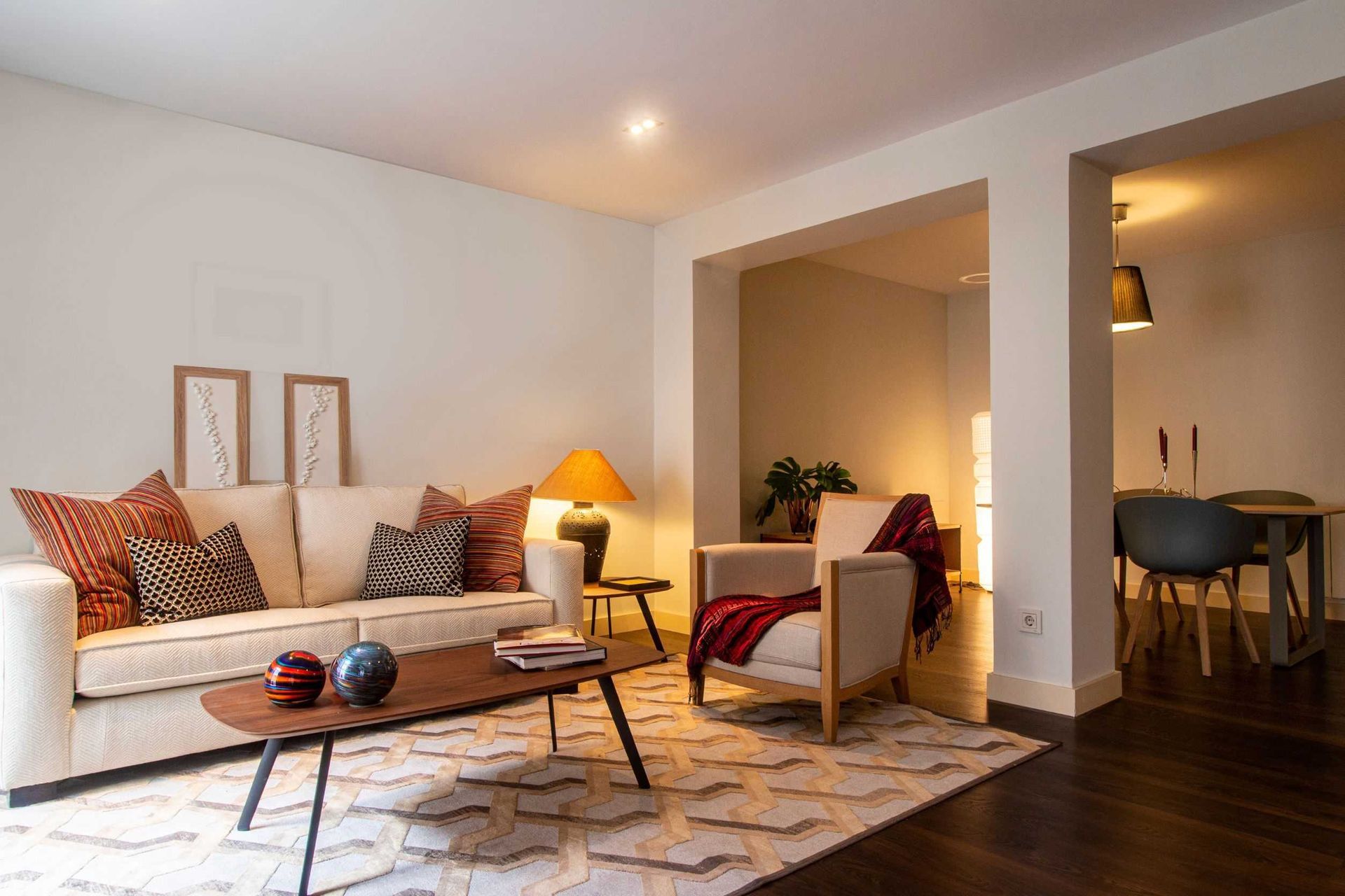 Una sala de estar con un sofá, una silla, una mesa de café y una alfombra.