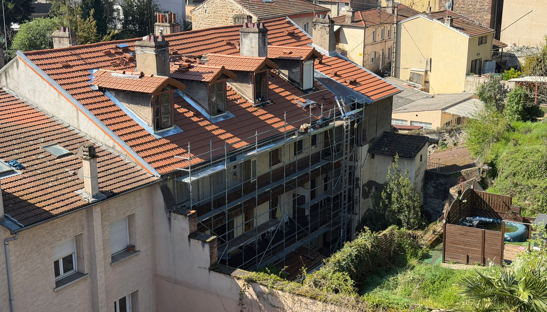 Toiture en tuiles d'une maison avec les cheminées et chiens-assis.