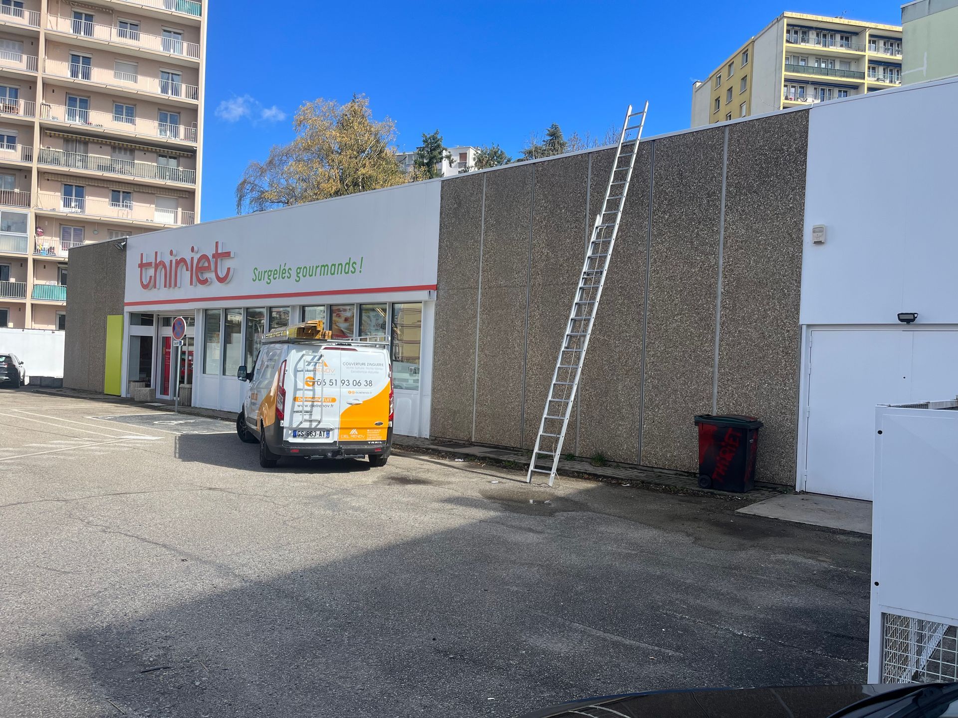 Une camionnette de société garée à côté d'un magasin. 