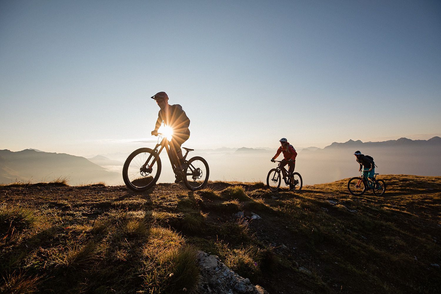 Eine Gruppe von Leuten fährt mit Fahrrädern auf einem Berggipfel.