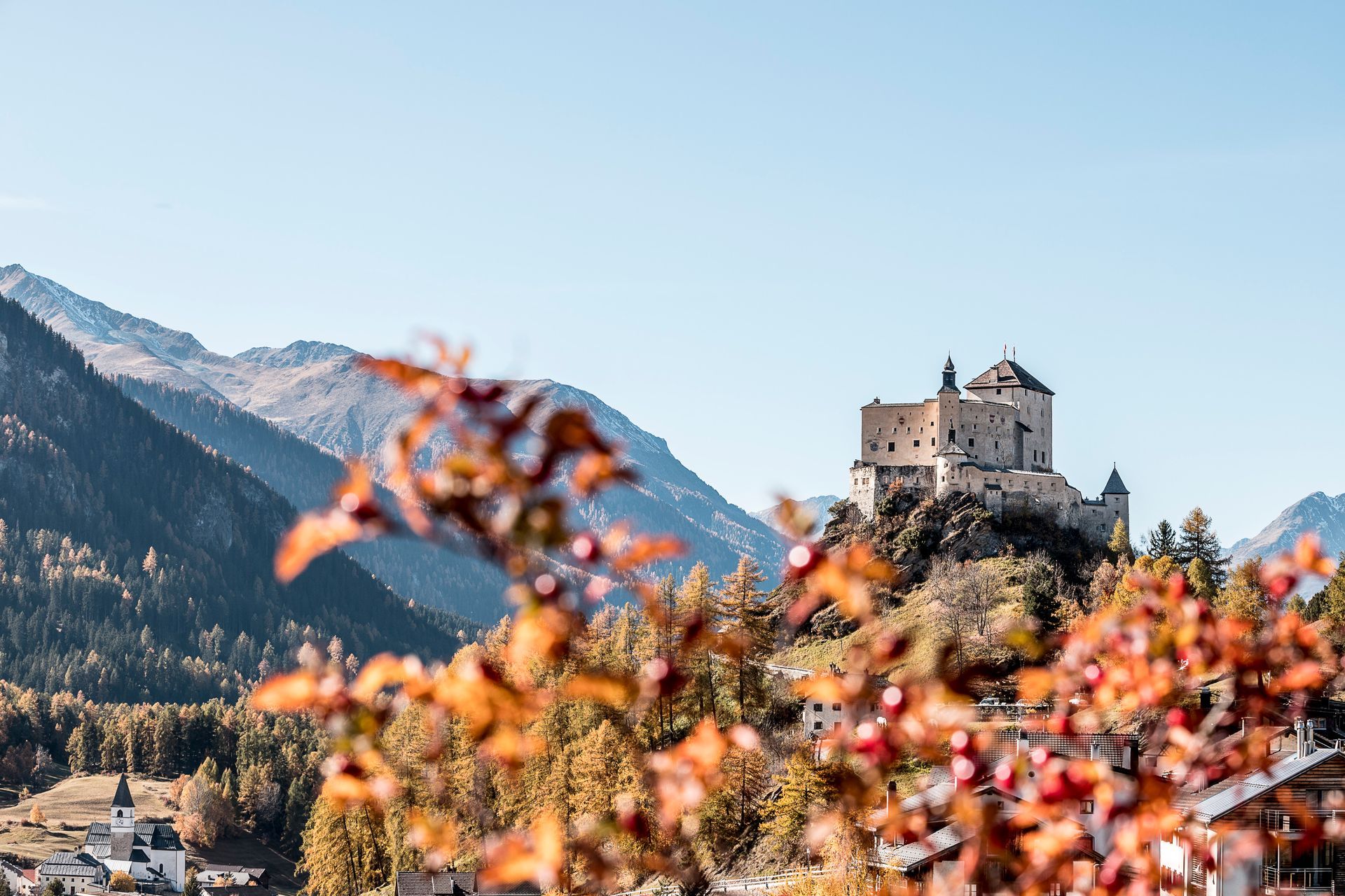 Eine Burg steht auf einem Berggipfel mitten in einem Wald.