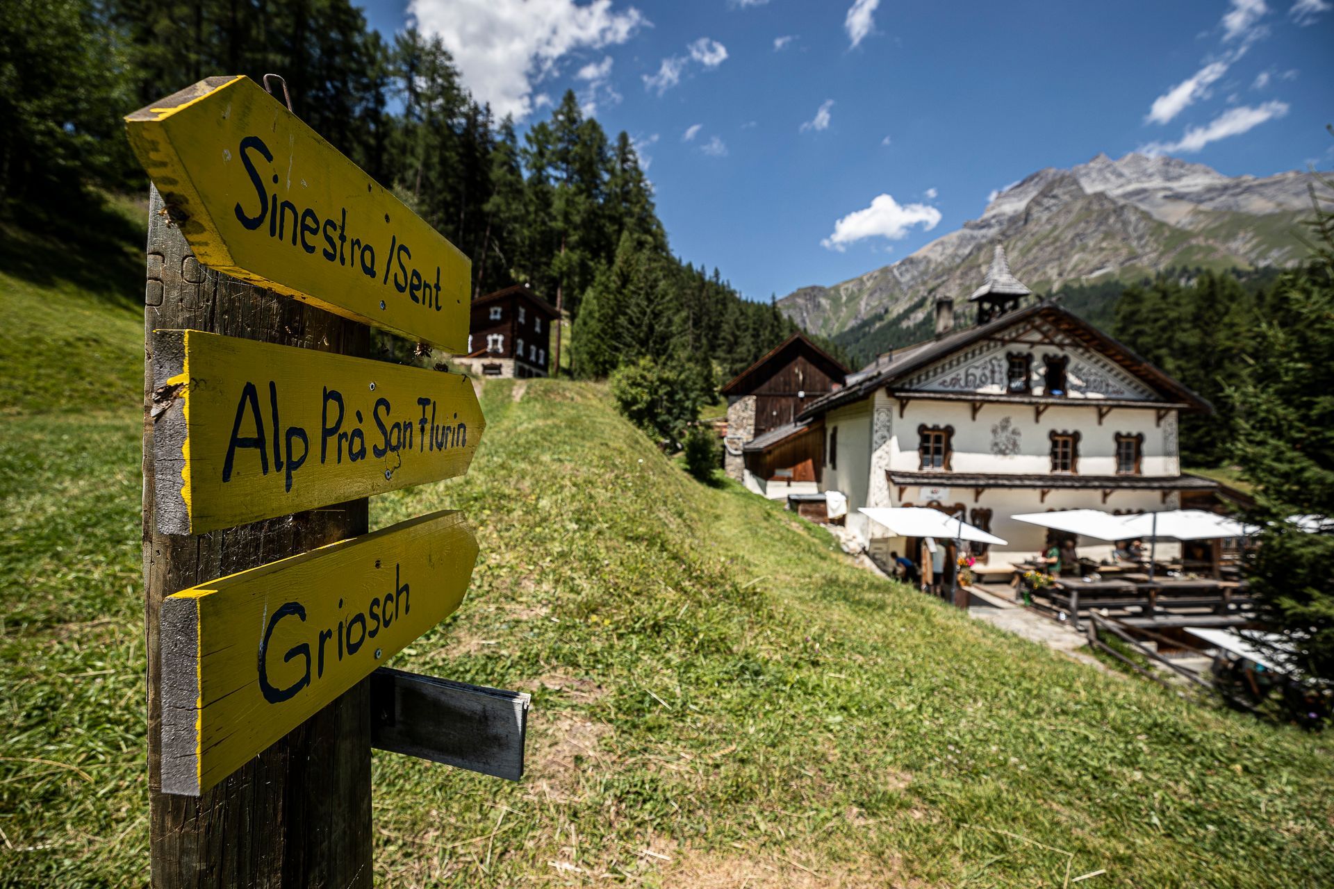 Ein gelbes Schild weist auf ein Haus in den Bergen