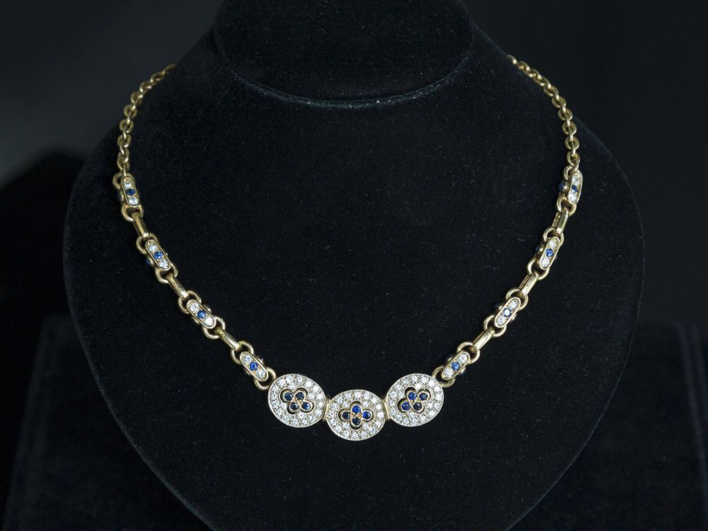 Collier en or et diamants sur un support noir