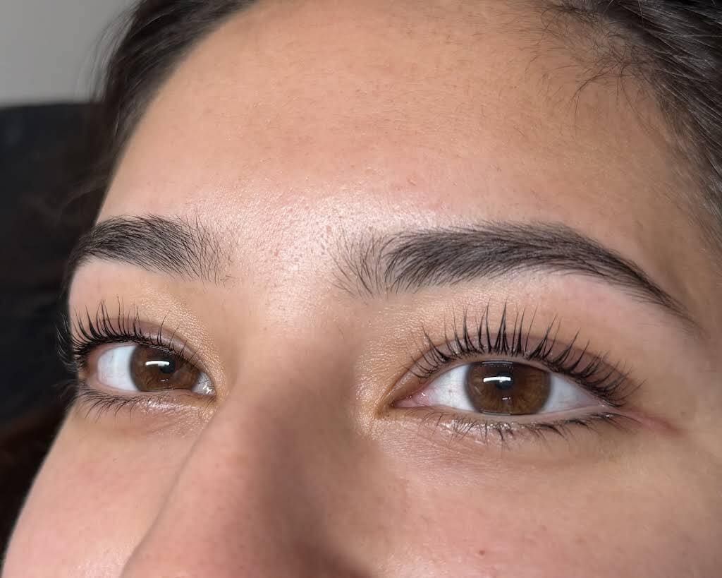Primer plano de ojos y cejas marrones, mostrando largas pestañas y una expresión neutra.