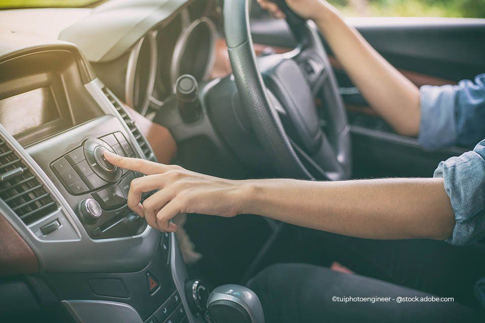 Eine Person bedient ein Autoradio