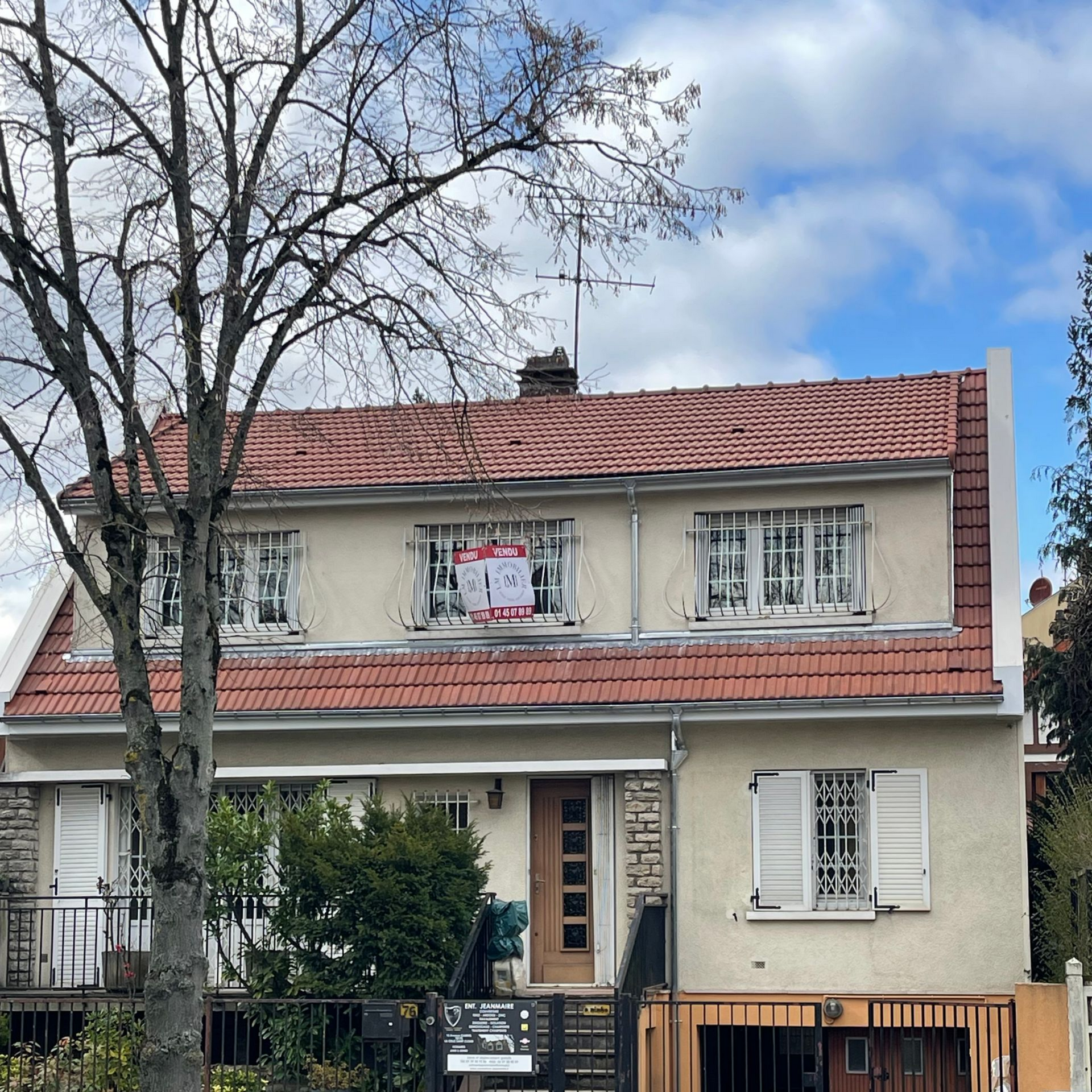 Une maison avec un panneau à vendre et une toiture neuve