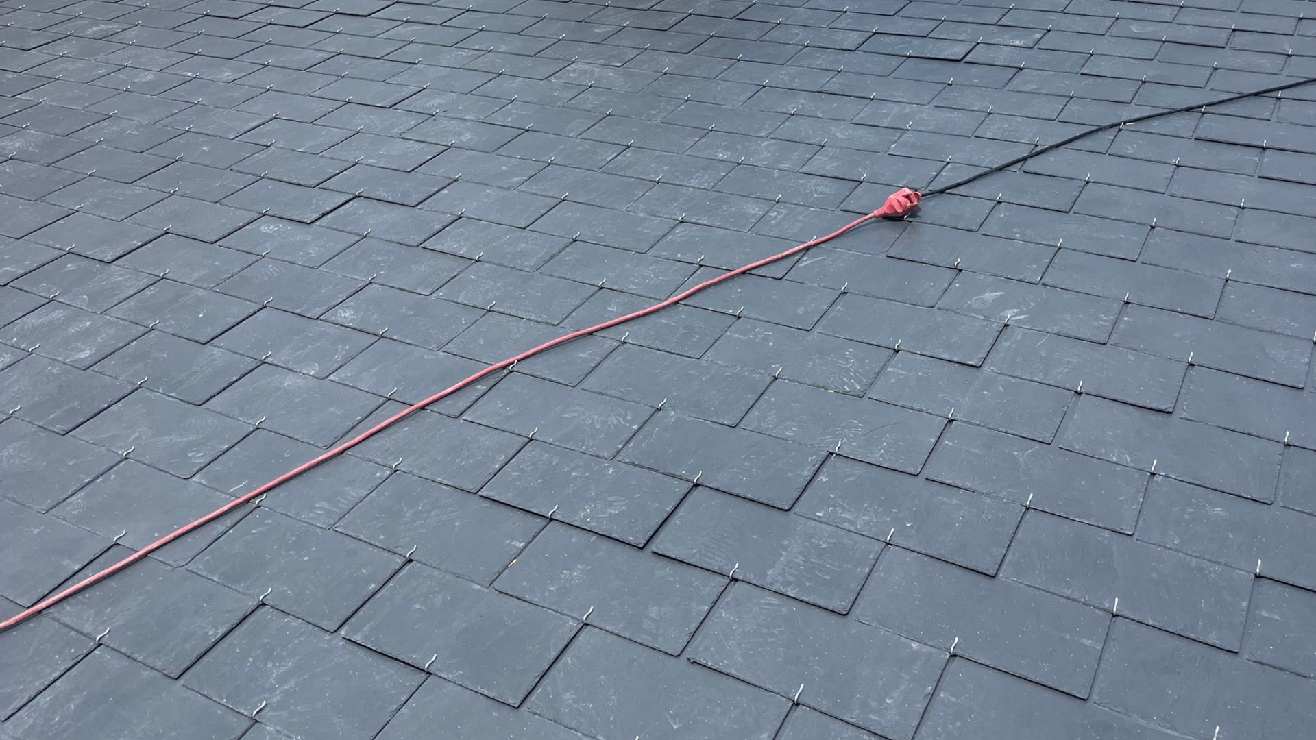 Un toit en ardoise tout propre avec un câble dessus