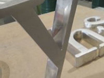 Una letra y de metal está encima de una mesa de madera.