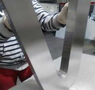 Una persona sostiene una barra de acero inoxidable en su mano.