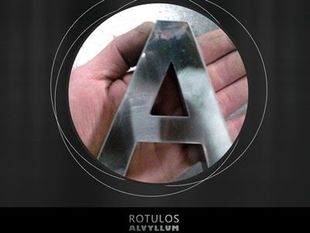 Una persona sostiene una letra de metal