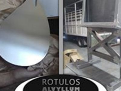 Un contenedor de acero inoxidable está junto a un camión en un garaje.