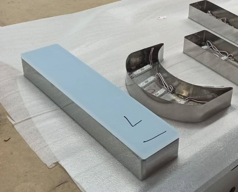 Una letra l de acero inoxidable está sobre una mesa.