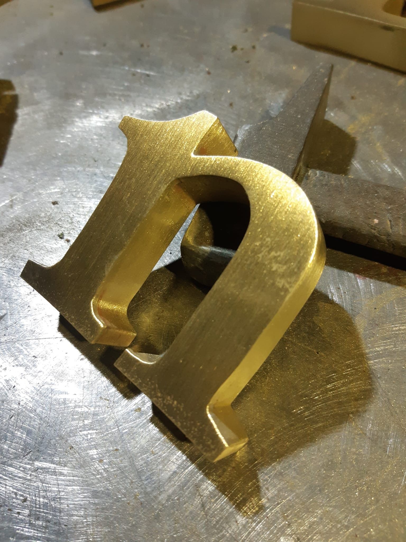 Una letra n dorada está sobre una superficie de metal.