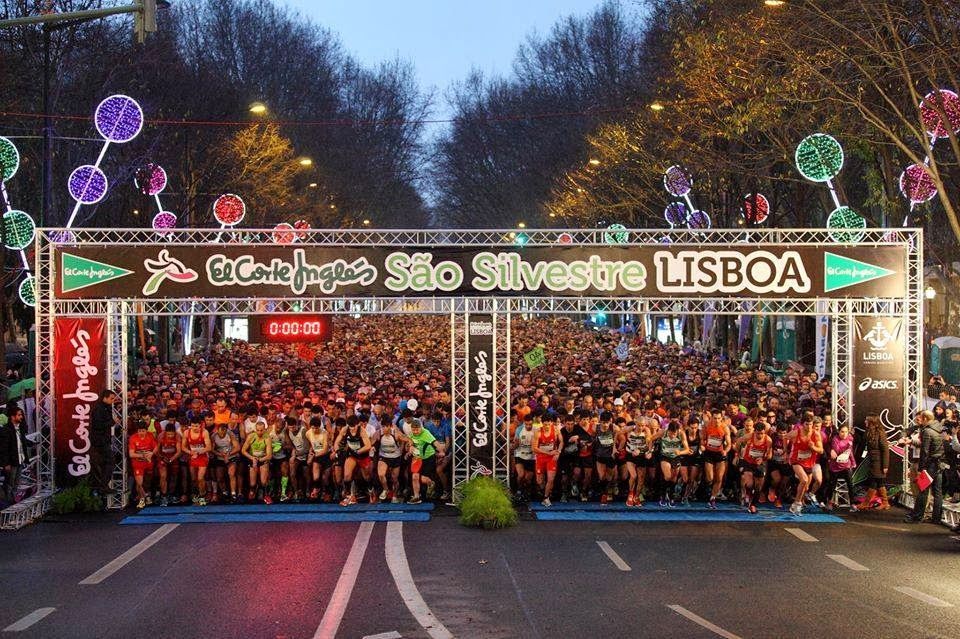 A large group of people are gathered under a sign that says sao silvestre lisboa